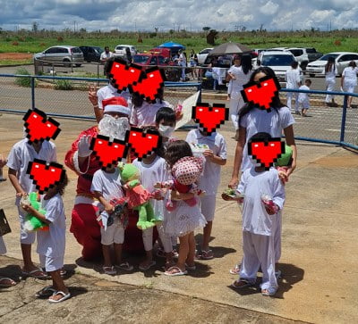 Crianças juntas com uniforme branco e corações no lugar