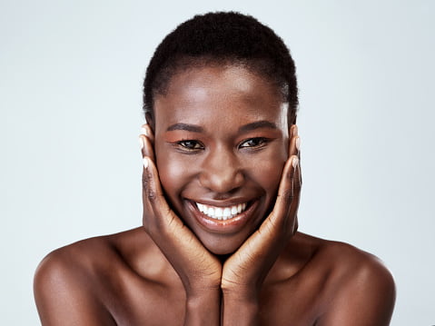 mulher negra sorrindo com pele brilhante