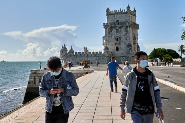turistas em frente à torre de belém, em portugal. foto colorida