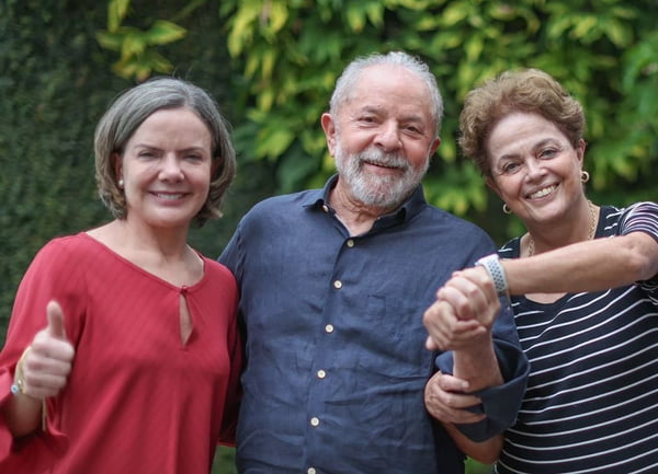Presidente do PT, Gleisi Hoffmann, em encontro com os ex-presidentes Lula e Dilma Rousseff. Eles sorriem em foto e dão as mãos - Metrópoles