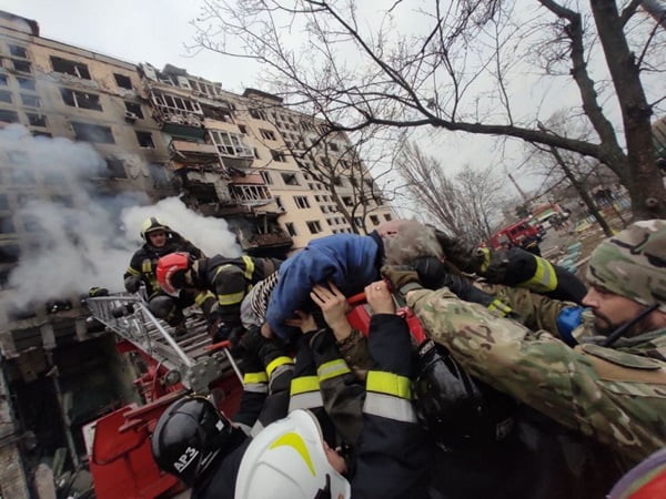 Pessoa sendo retirada de dentro de um prédio em chamas