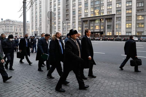 Presidente Bolsonaro anda acompanhado de comitiva pelas ruas Moscou, na Rússia. Ele usa sobretudo e está sem máscara - Metrópoles