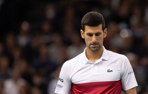 Novak Djokovic, tenista líder do ranking da ATP, na final do Master Series de Paris, França. Ele é branco, usa camiseta branca com listras vermelha e azul - Metrópoles