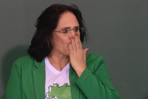 Em foto no Planalto, a ministra Damares Alves participa do lançamento do projeto "Brasil para Todos" e manda um beijo para a plateia. Ela usa uma roupa verde - Metrópoles