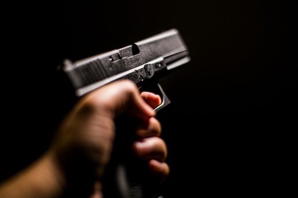 Porte e porte de arma. pessoa segurando uma arma de fogo na cor preta em uma das mãos- Metrópoles