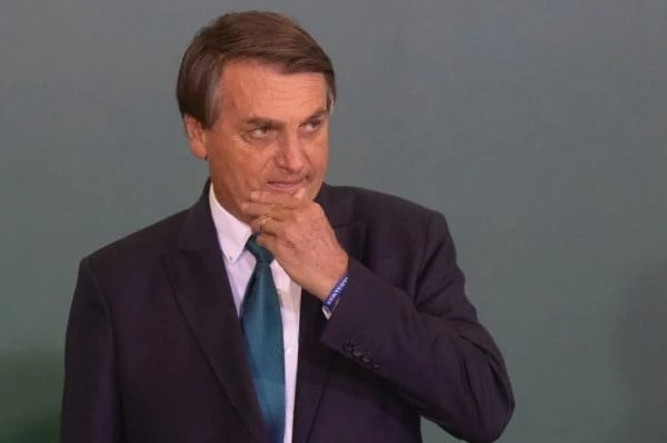 Bolsonaro, presidente do Brasil entre os anos 20018 e 2022. Ele usa terno e gravata e camiseta clara- Metrópoles