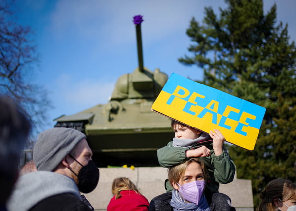 Participantes protestam contra a guerra na Ucrânia com uma placa com a inscrição "Paz" no memorial aos soldados soviéticos mortos na Segunda Guerra Mundial em frente a um tanque soviético T34