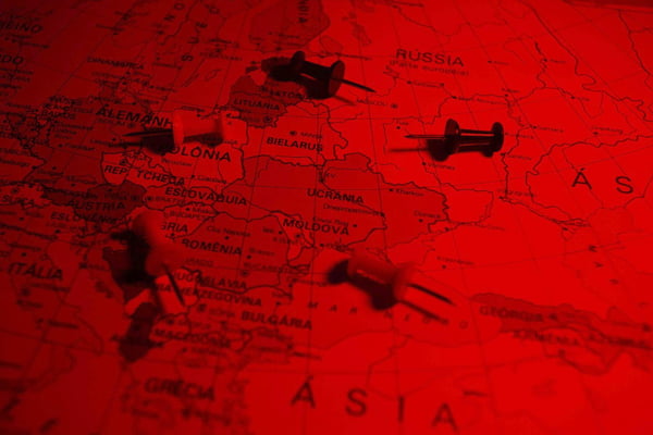 Imagem ilustrativa de mapa da Eurásia, mostrando Rússia e Ucrânia com alfinetes jogados por cima, num filtro vermelho - Metrópoles