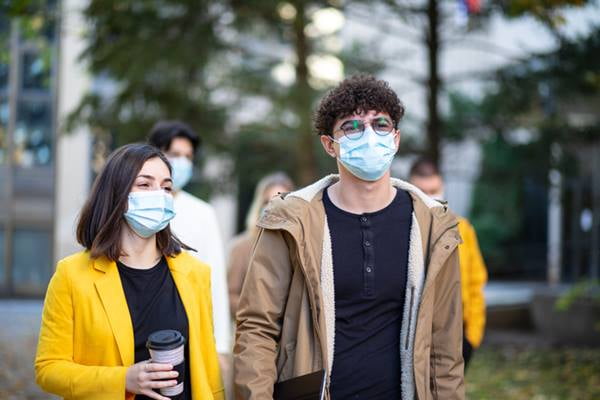 Pessoas passeando e utilizando máscaras na cor azul