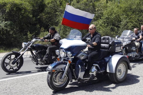 Putin anda de moto Harley-Davidson acompanhado de outros homens. A bandeira da Rússia aparece em uma das motos - Metrópoles