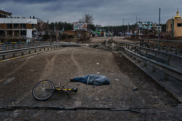 Em Irpin, cidade da Ucrânia, corpo de civil é visto jogado no chão próximo a uma bicicleta, em cenário devastado da cidade após ataque russo - Metrópoles