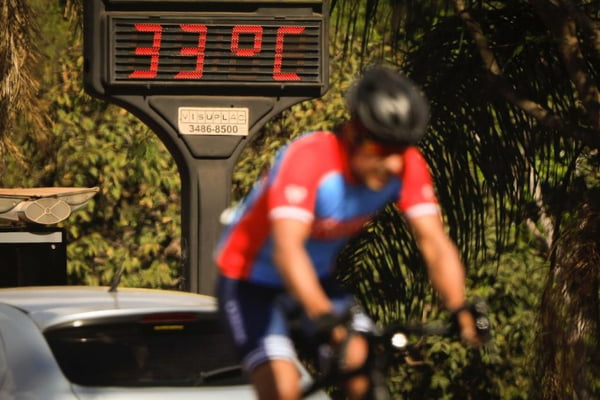 Ciclista faz esporte próximo ao termometro marcando 33 graus