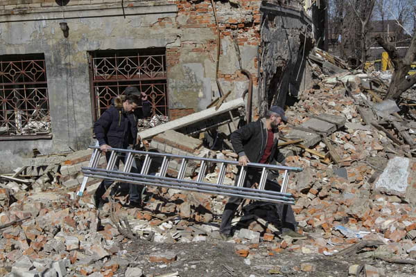 Civis levam escada para acessar prédio destruído por ataque russo em meio a escombros em Dnipro, Ucrânia - Metrópoles