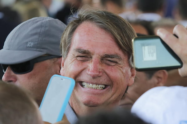 Presidente Bolsonaro em inauguração do Reservatório do Ipiranga, em São Paulo. Ele sorri em meio a uma multidão com celulares - Metrópoles