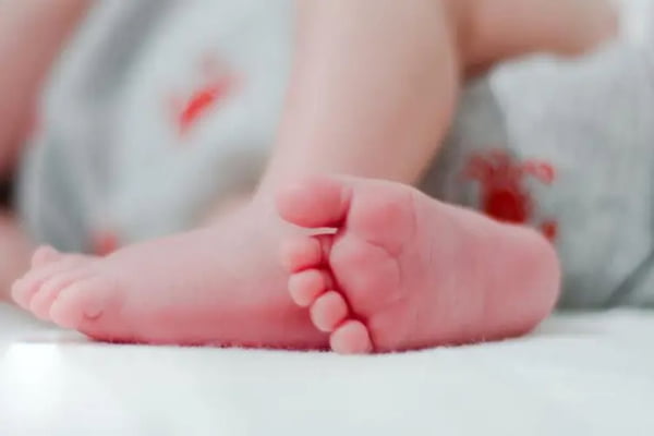 Bebê branco com marcas de sangue na fralda