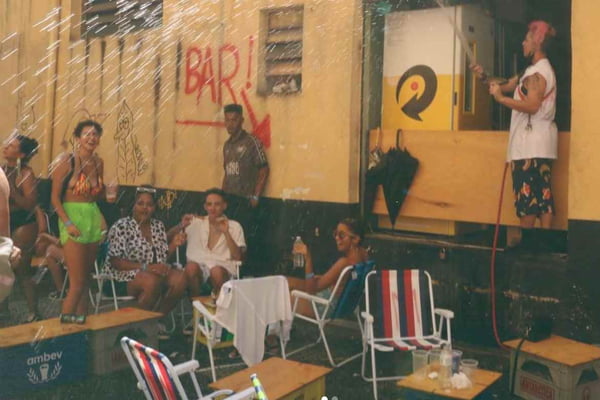 Bar Miúda, em São Paulo, onde pessoas se sentam em cadeiras de praia e um homem joga água sob elas com mangueira. Uma mãe foi impedida de entrar no estabelecimento com seu filho - Metrópoles