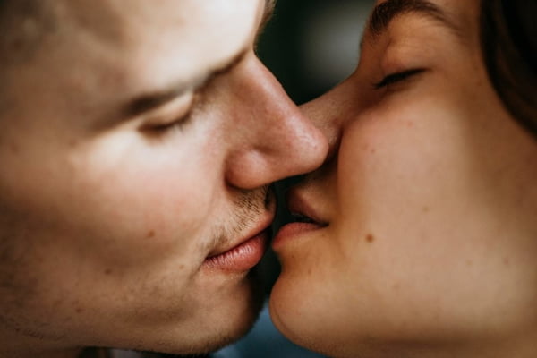 Um homem e uma mulher branca se beijando