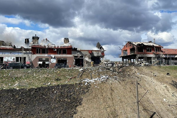 Cidade de Lviv, na Ucrânia, é bombardeada por misseis russos. Na foto, várias casas aparecem destruídas e uma cratera formada na frente delas - Metrópoles