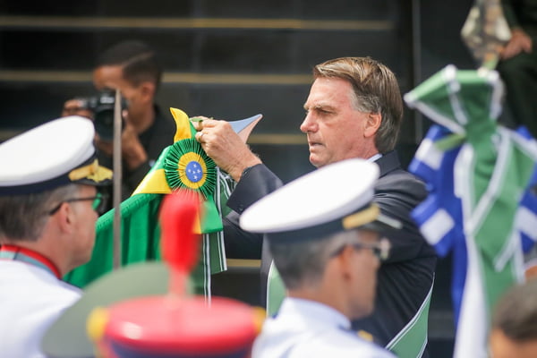 O presidente Bolsonaro coloca faixa da República em haste segurada por militar na cerimônia militar em comemoração ao Dia do Exército, marcando os 374 anos da instituição - Metrópoles