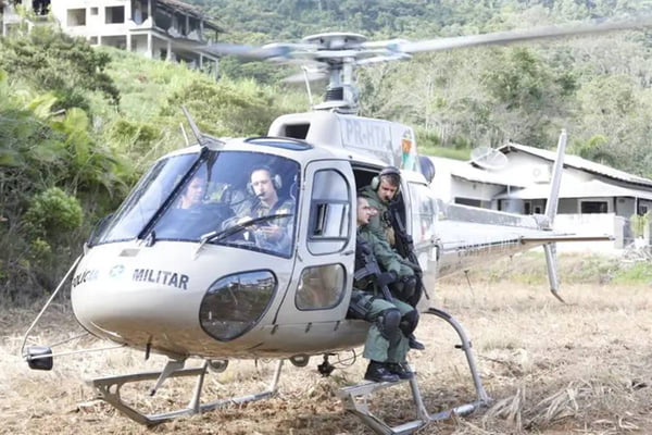quatro agentes do BOPE dentro de um helicóptero