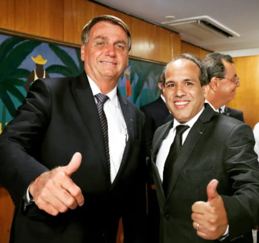 O presidente Bolsonaro e o intérprete de Libras da Presidência, Fabiano Guimarães. Eles sorriem para foto e fazem sinal de joinha com as mãos - Metrópoles
