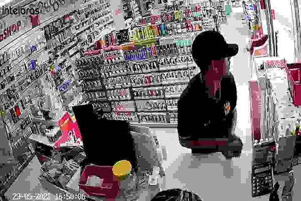 homem roubando dinheiro de balcão em farmácia