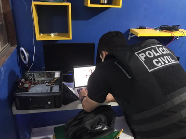 policiais analisando computador