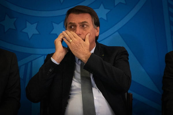 Presidente Jair Bolsonaro conversa ao celular no planalto