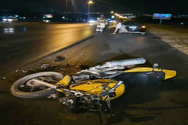 foto colorida de moto amarelo caída no asfalto após acidente