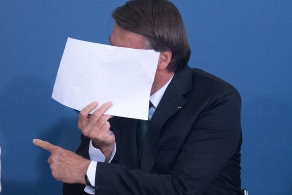 Presidente Jair Bolsonaro coloca folha no rosto durante solenidade alusiva à Política Nacional para Recuperação das Aprendizagens na Educação Básica e ao MECPlace no palacio planalto em brasília