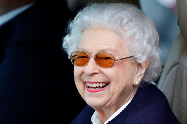 Foto colorida. Mulher idosa branca sorridente. Ela tem cabelos brancos e sorri