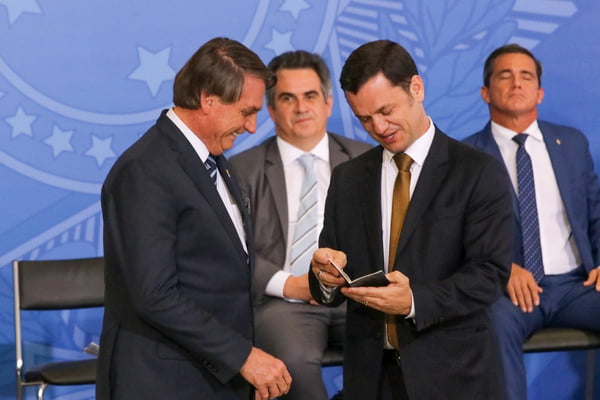 Presidente Jair Bolsonaro entrega o novo passaporte ao ministro da justiça Anderson Torres, durante lançamento do novo documento no Palácio do Planalto