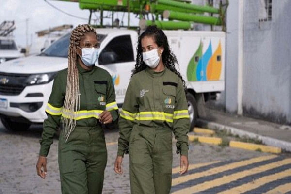 Foto colorida de duas mulheres usando uniformes da Neoenergia e usando máscaras-Metrópoles