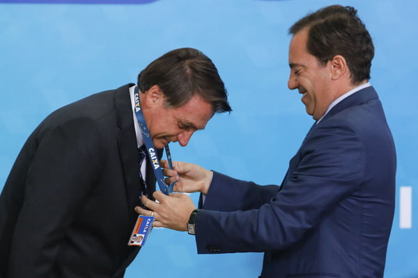 Pedro Duarte Guimarães presidente da caixa economica federal entrega um cracha da caixa para o presidente Jair Bolsonaro