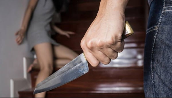 Homem segura faca diante de mulher, em segundo plano, que se escora com medo em escada - Metrópoles