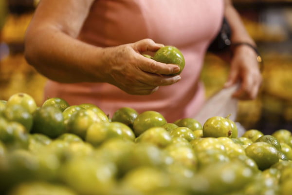 mulher escolhe fruta em mercado de goiania