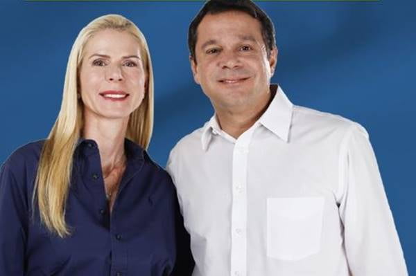 Fotografia colorida de mulher de azul e homem de camiseta branca lado a lado