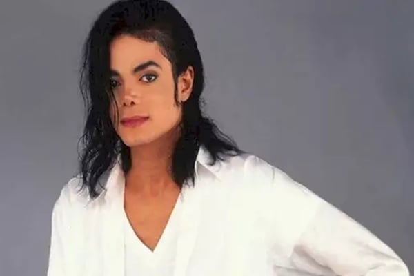 Foto colorida de Michael Jackson usando blusa branca - Metrópoles