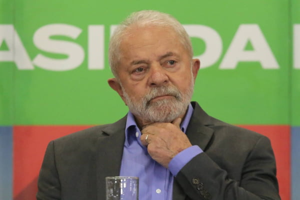 ex-presidente Luiz Inácio Lula da Silva com a mão no pescoço