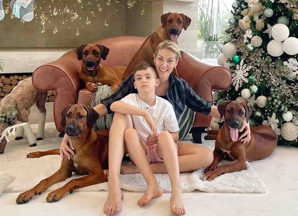 Ana Hickan, seu filho e alguns dos cachorros da família