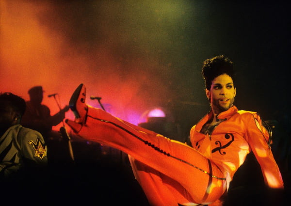 Na imagem com cor, o cantor Prince em apresentação ao vivo