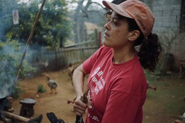 Atriz Maeve Jinkings em cena do filme Carvão, na imagem a personagem Irene segura uma galinha com os pés - Metrópoles