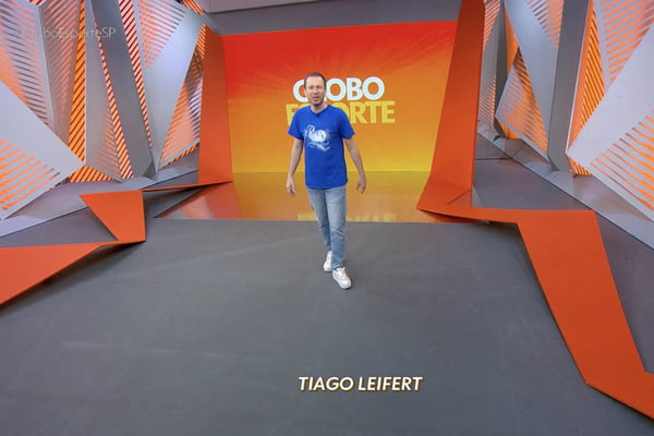 Tiago Leifert, de camiseta azul e calça jeans, volta ao estúdio do Globo Esporte após 7 anos - Metrópoles