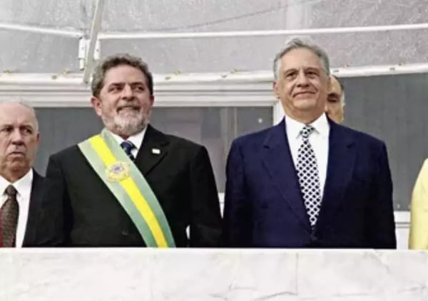 Imagem colorida dos presidente Lula e Fernando Henrique Cardoso no dia da posse de Lula. Esse usa a faixa presidente e ambos sorriem, de cima do Planalto - Metrópoles