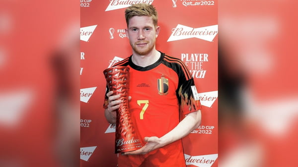 Em imagem colorida, Kevin de Bruyne, vestido com a camisa vermelha do time da Bélgica, segura troféu de melhor em campo diante do Canadá - Metrópoles