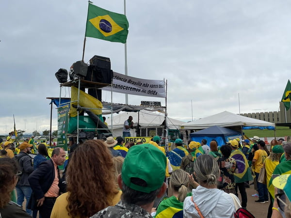 Militantes bolsonaristas protestam no QG do Exército, em Brasília, com carros de som e barracas armadas. Eles usam verde e amarelo - Metrópoles