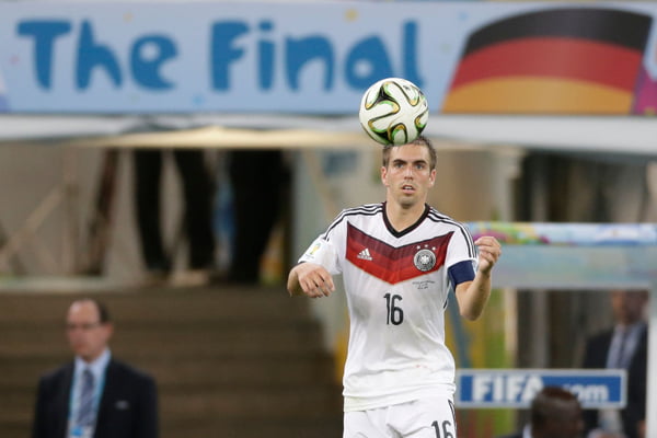 Imagem colorida mostra o jogador Philipp Lahm com o uniforme da Alemanha e olhando para uma bola - Metrópoles