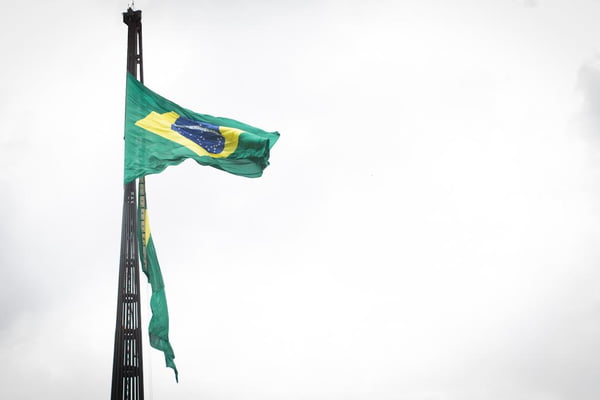 Fotografia colorida da bandeira nacional sendo trocada no mastro - Metrópoles