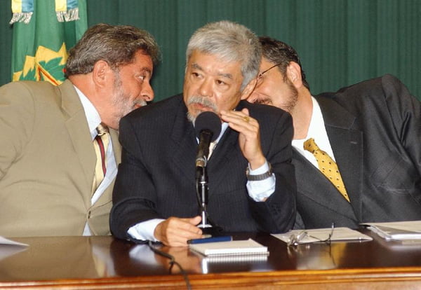 Lula cochicha para Antonio Palocci durante discurso de Luiz Gushiken, em foto tirada em maio de 2003