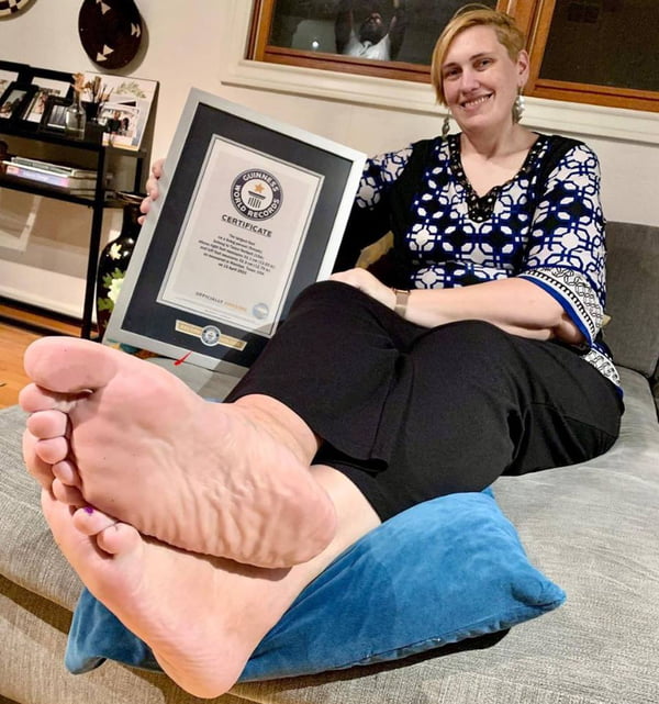 Mulher mostra placa com prêmio de maiores pés do mundo - Metrópoles
